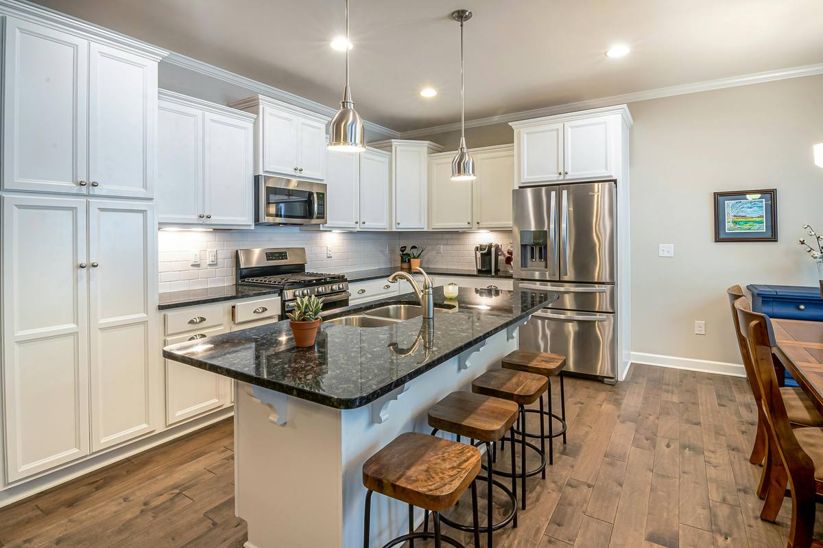 Spotless kitchen with white cabinets and granite countertops
